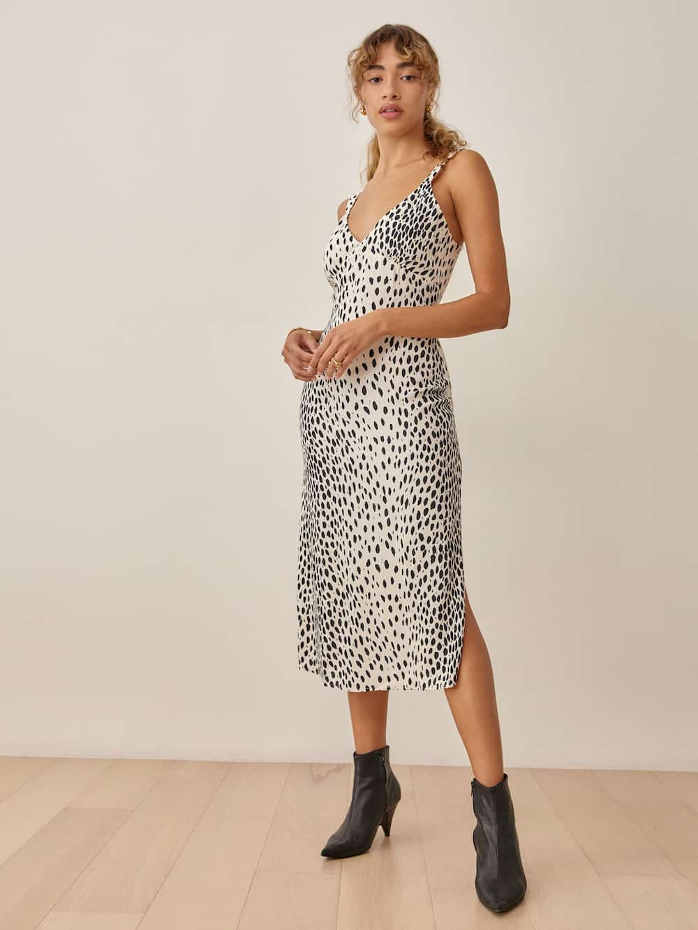 image of a woman in a black and white cheetah animal print slip dress and black booties