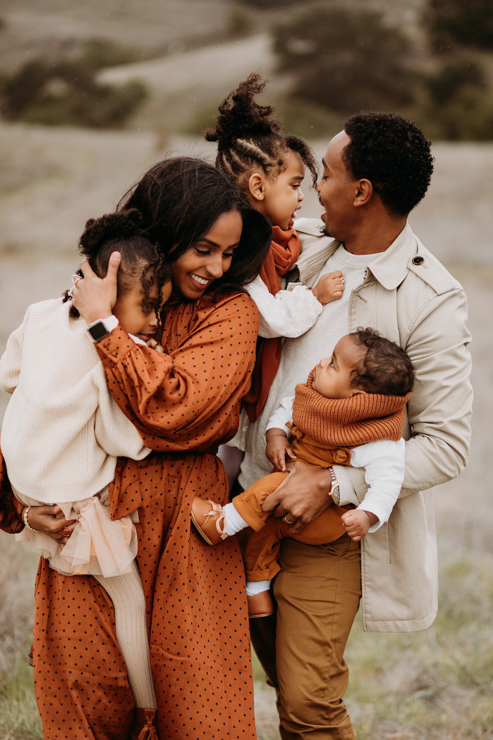 image of a black family in a fall photoshoot wearing orange and cream color clothing
