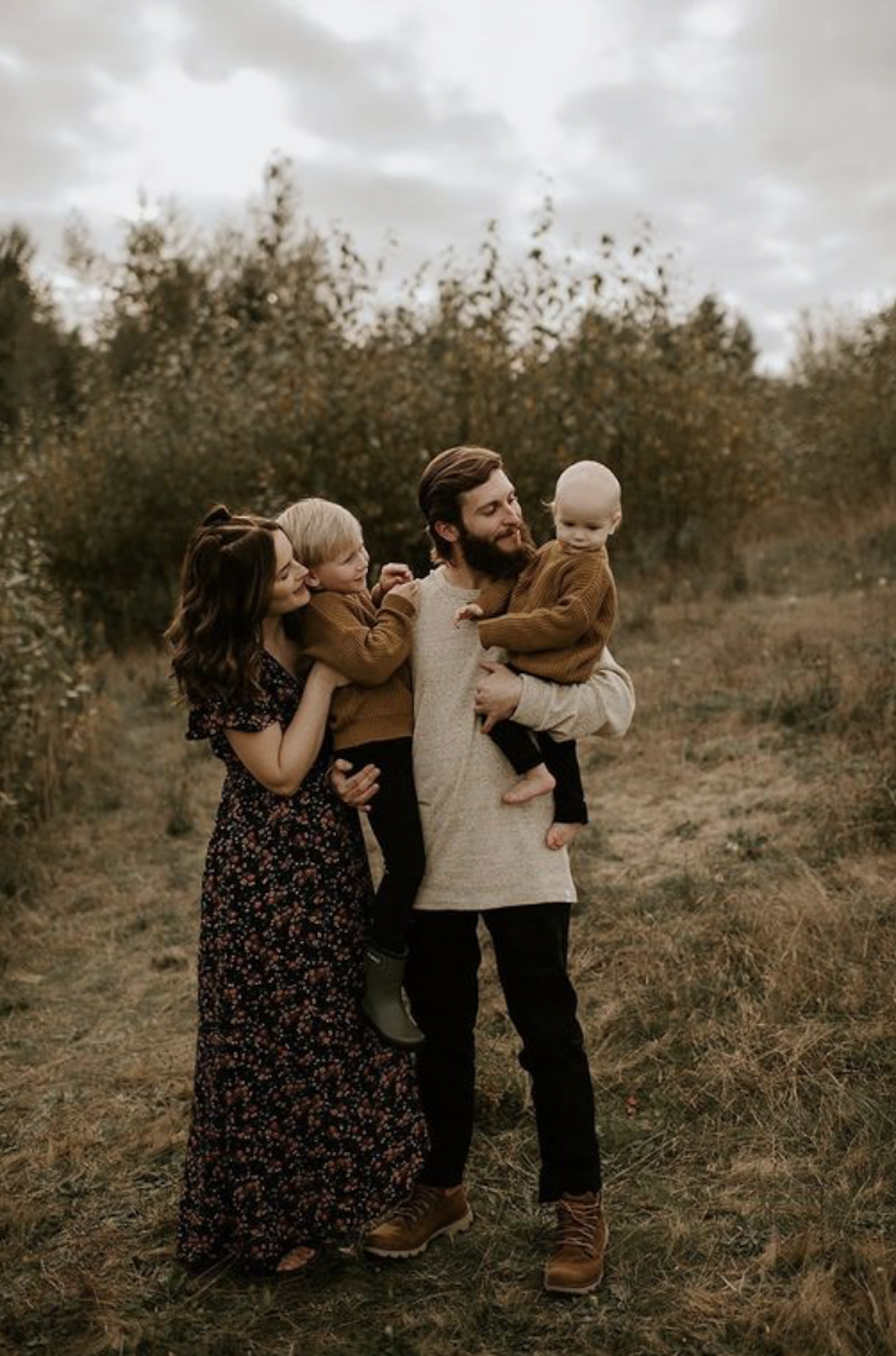 image of a fall family photo session with a man, woman, and two children in neutral outfits and the mom in a long black maxi floral dress