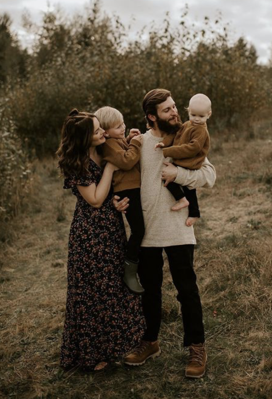 image of a fall family photo session with a man, woman, and two children in neutral outfits and the mom in a long black maxi floral dress