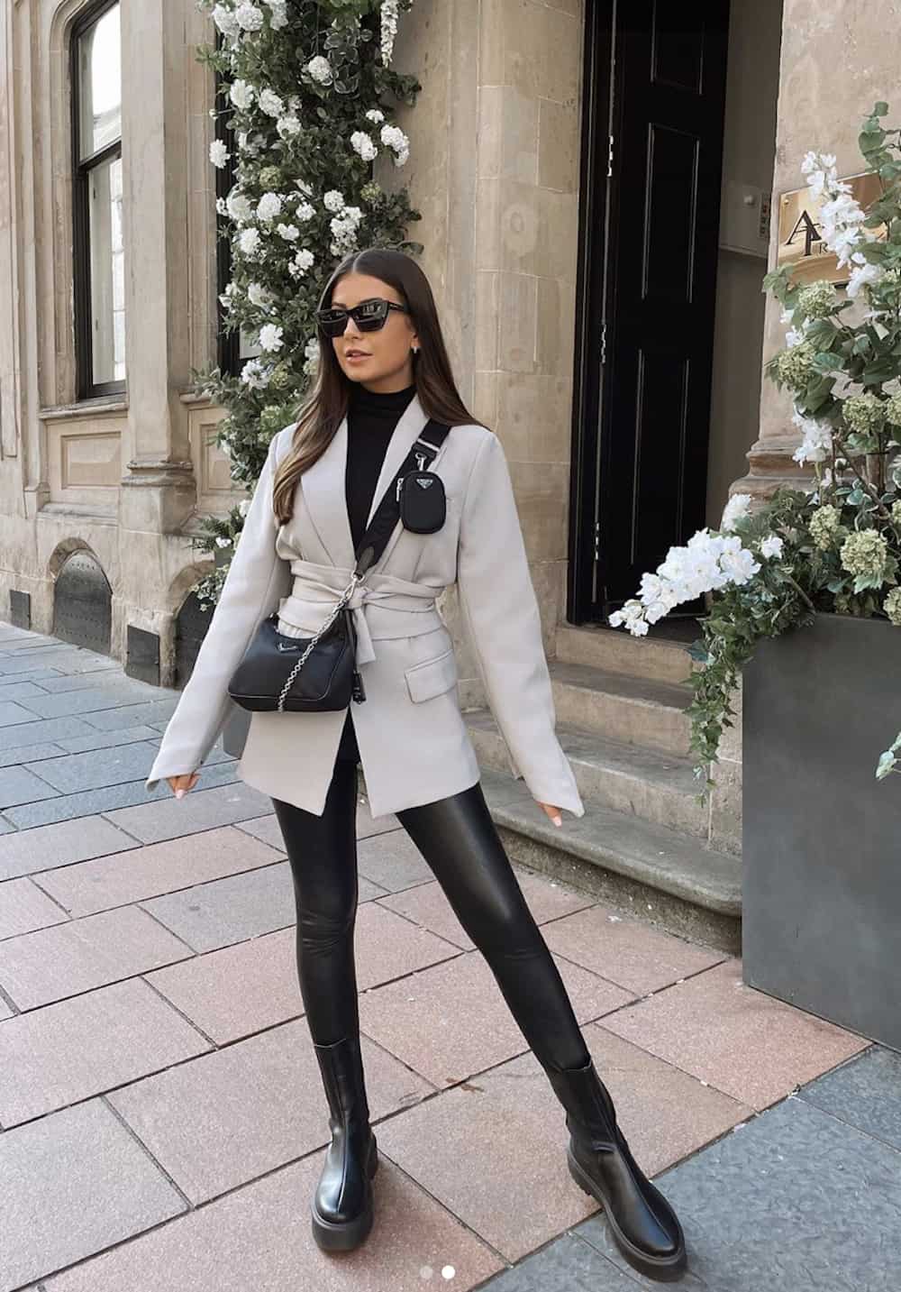 image of a woman wearing a grey blazer jacket, black faux leather leggings, and black lug boots
