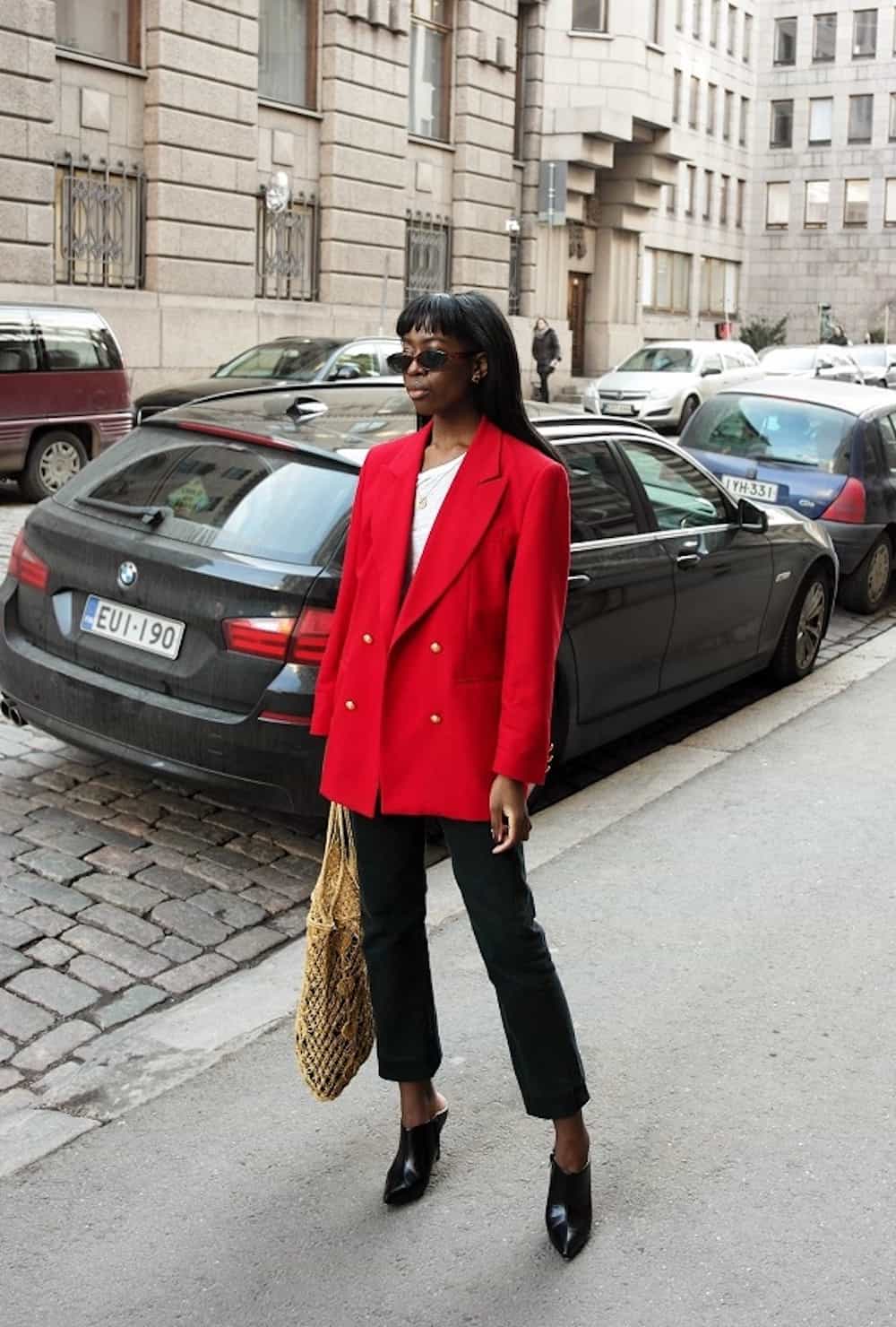 image of a stylish black woman in a red blazer, black trousers, and black heels