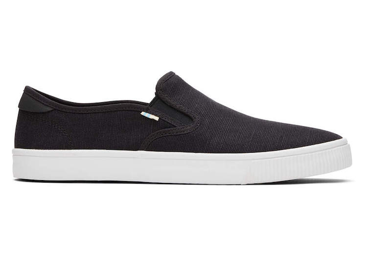 image of a simple black slip on canvas sneaker with a white sole