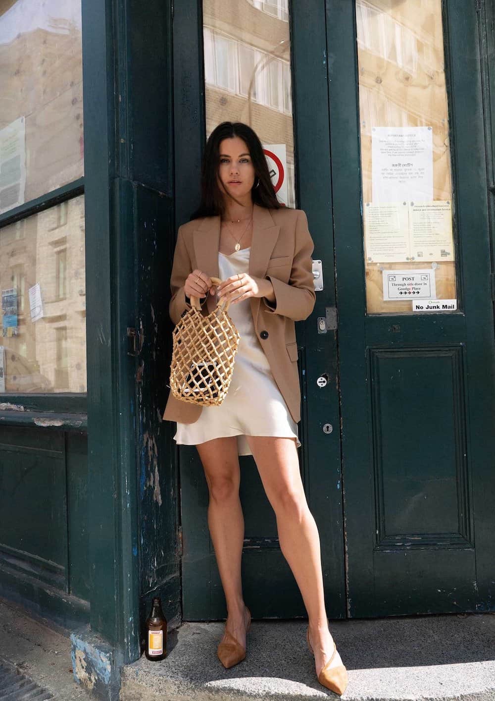 image of a woman in a camel oversized blazer with an ivory slip dress and heels