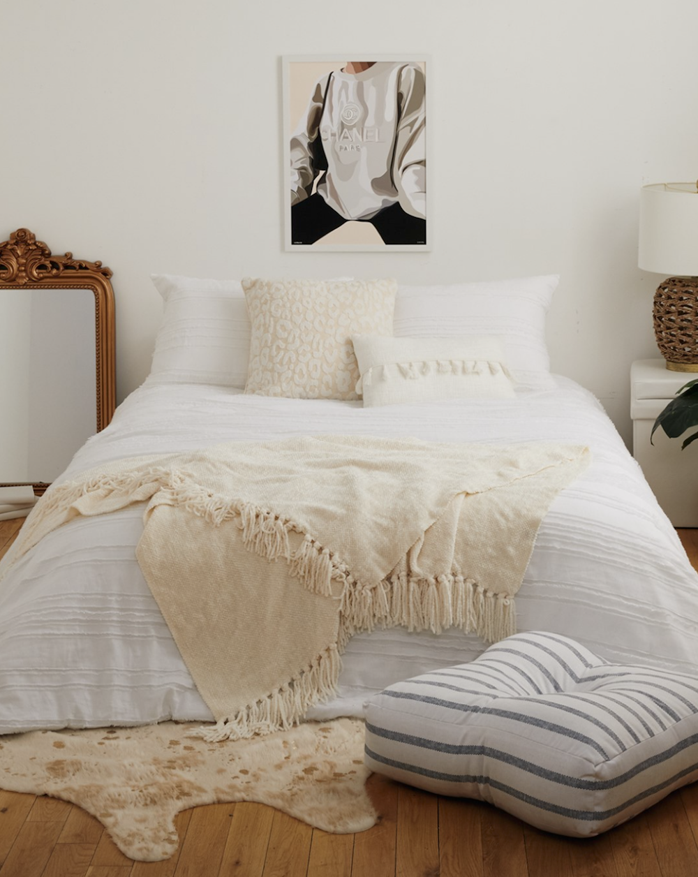 image of a bed with white linens in a white room with boho decor