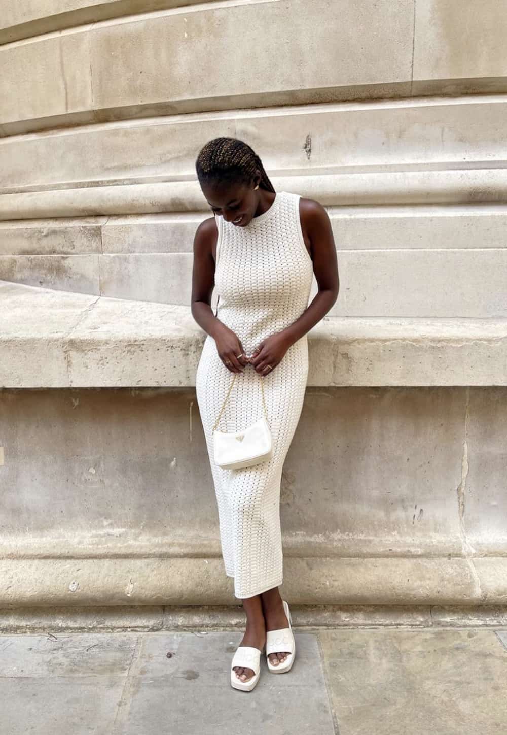 image of a black woman in an ivory ribbed knit midi dress and white puffy sandals