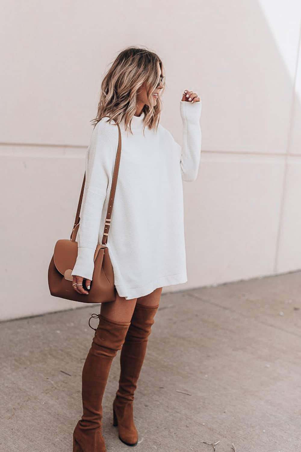 image of a woman in a white sweater dress and over the knee brown suede boots