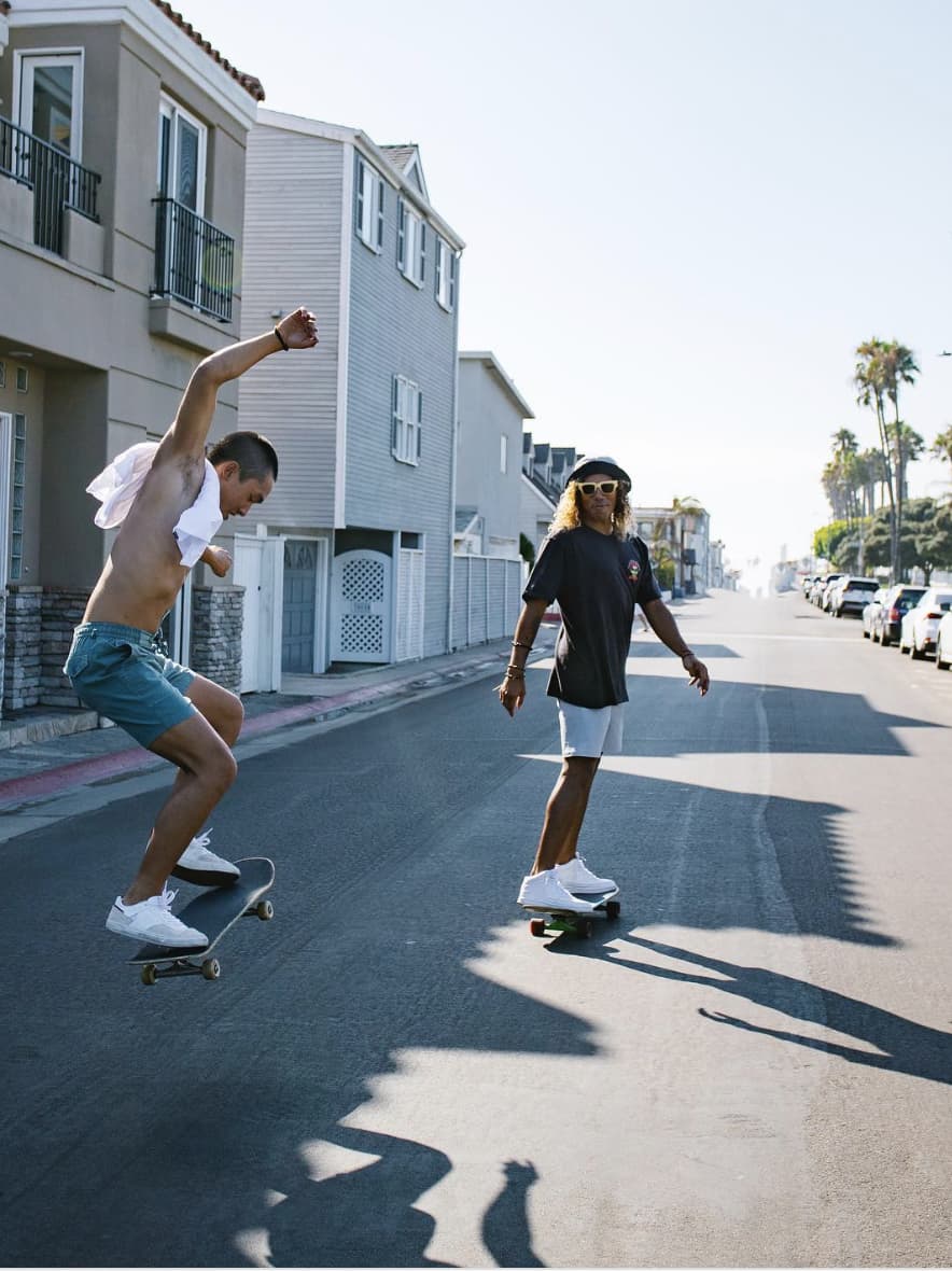 image of two men skateboarding in the street wearing casual clothing