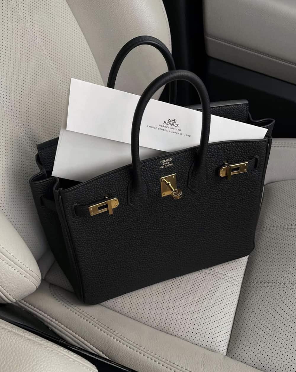 image of a black Hermes Birkin 25 bag sitting on a car seat