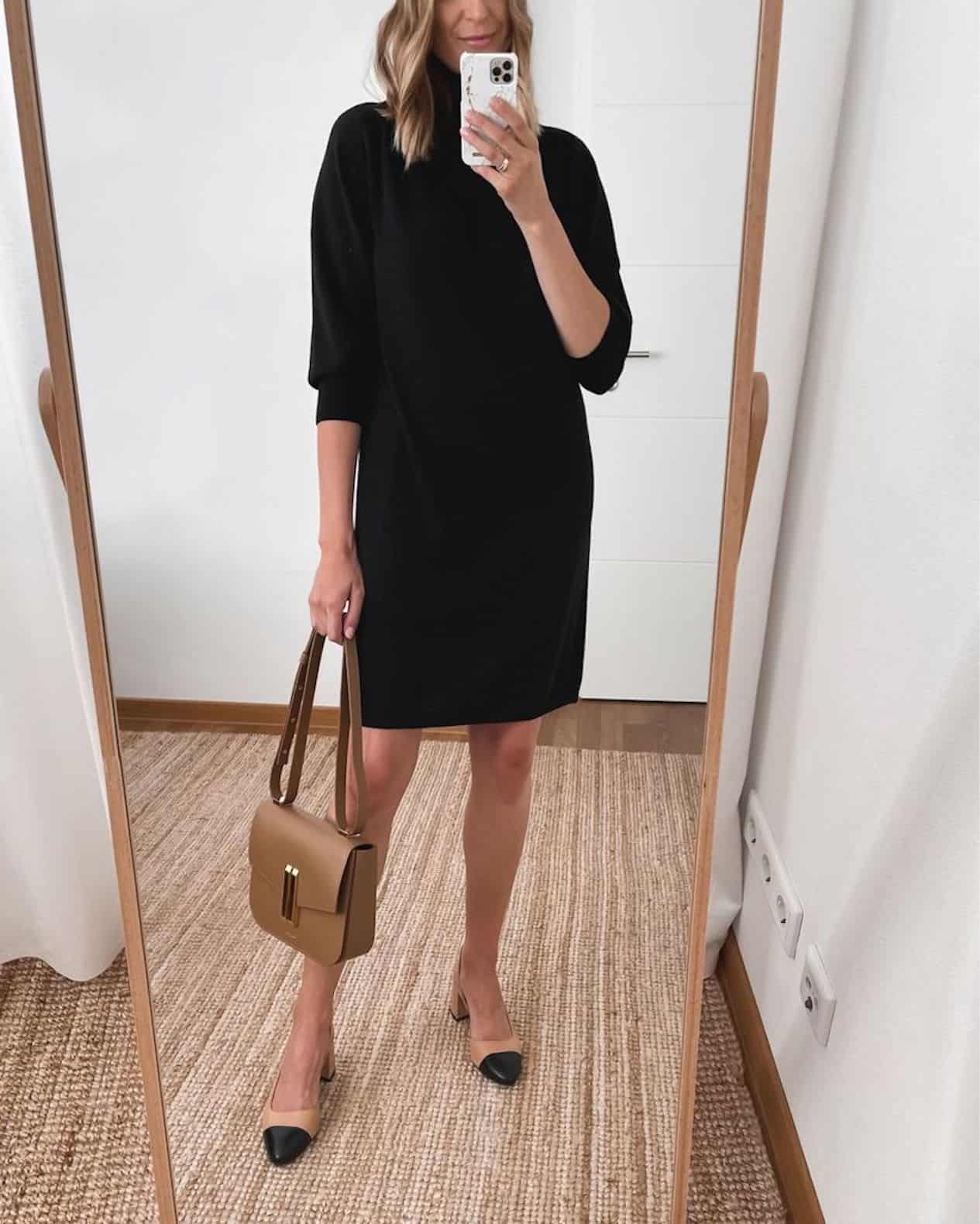 Woman wearing a black sweater dress and Chanel-style block heel pumps.