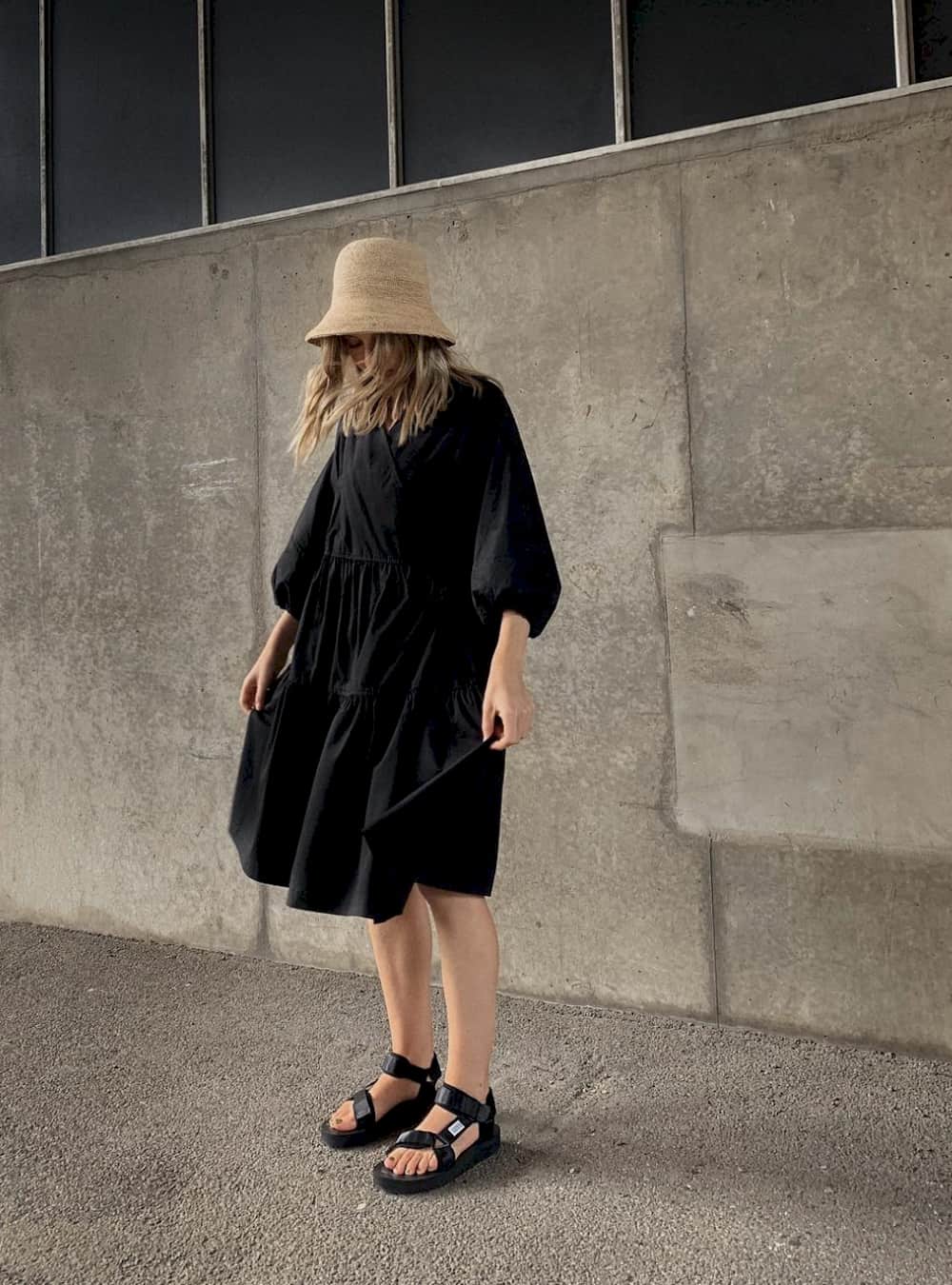 Woman wearing a black dress and sandals.