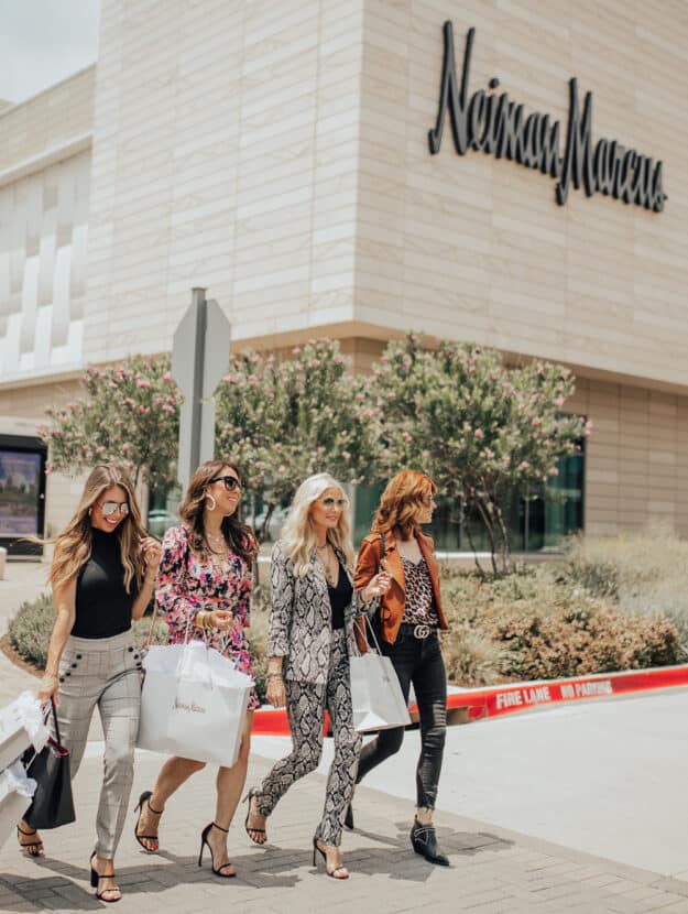 image of four fashionable women walking in front of a Neiman Marcus store