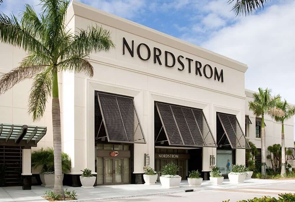 image of a Nordstrom storefront with black windows and palm trees in front