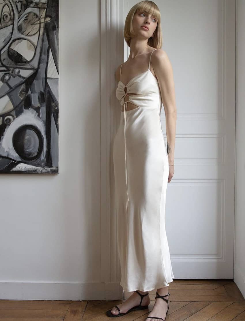 Woman wearing a white silk slip dress.