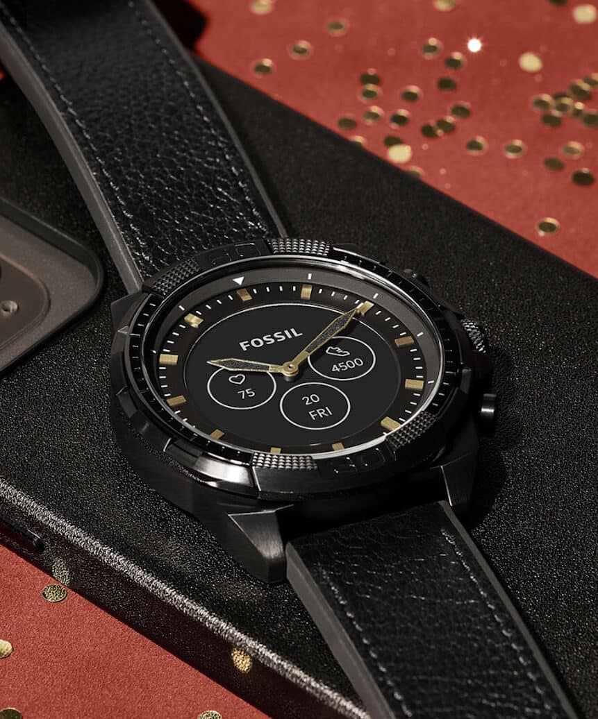 image of a black watch with black leather watch strap on a red table