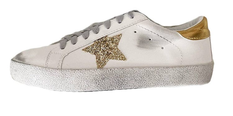 image of a white sneaker with distressing and a gold sequin star detail on the side 