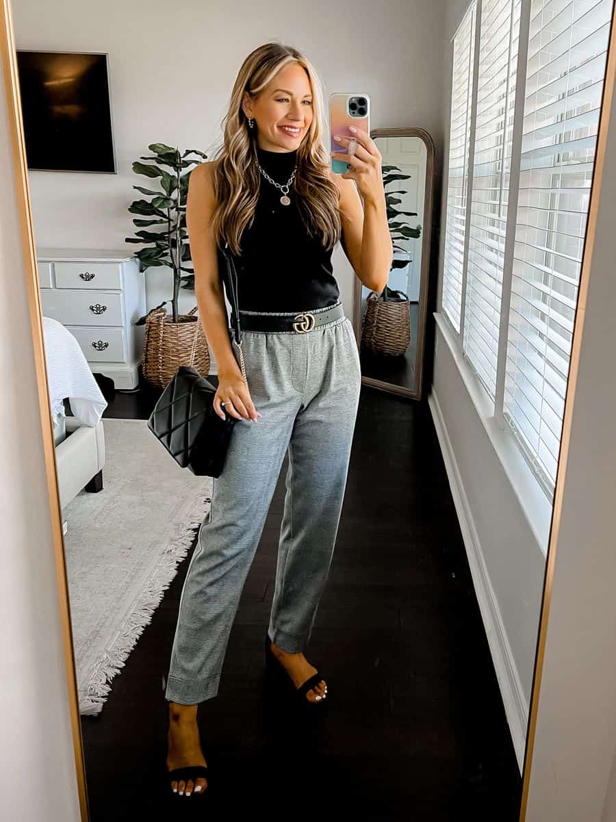 image of a woman wearing dress pants, a black Gucci belt, a black tank top and heeled sandals