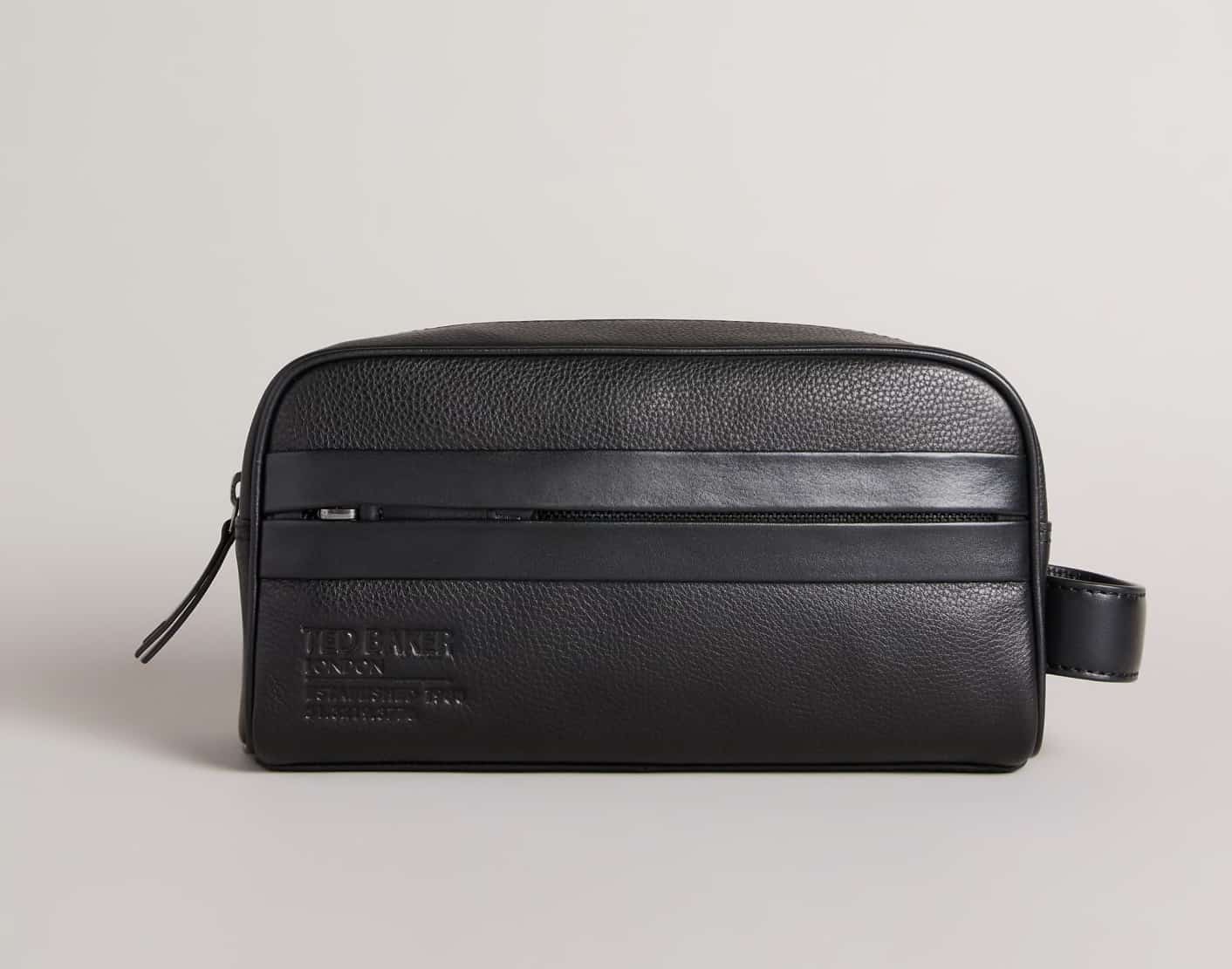 image of a black leather Ted Baker toiletry bag with a zipper and embossed logo