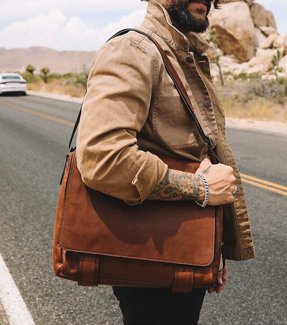 image of a bearded man wearing a brown tan jacket with a rustic brown leather messenger bag on his shoulder
