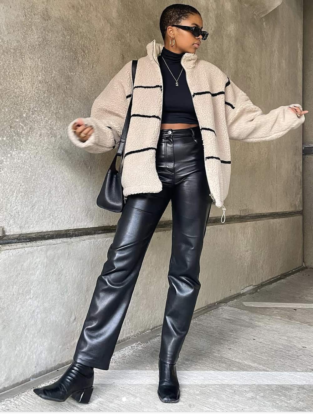 image of a black woman in a chic outfit with a sherpa jacket, black leather pants, and black leather boots