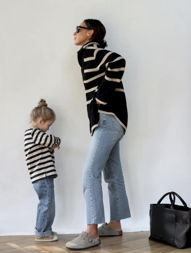 image of a mom and her toddler, both wearing striped sweaters and jeans