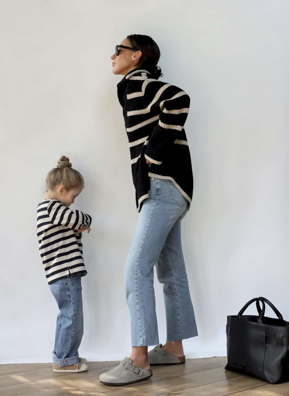 image of a mom and her toddler, both wearing striped sweaters and jeans