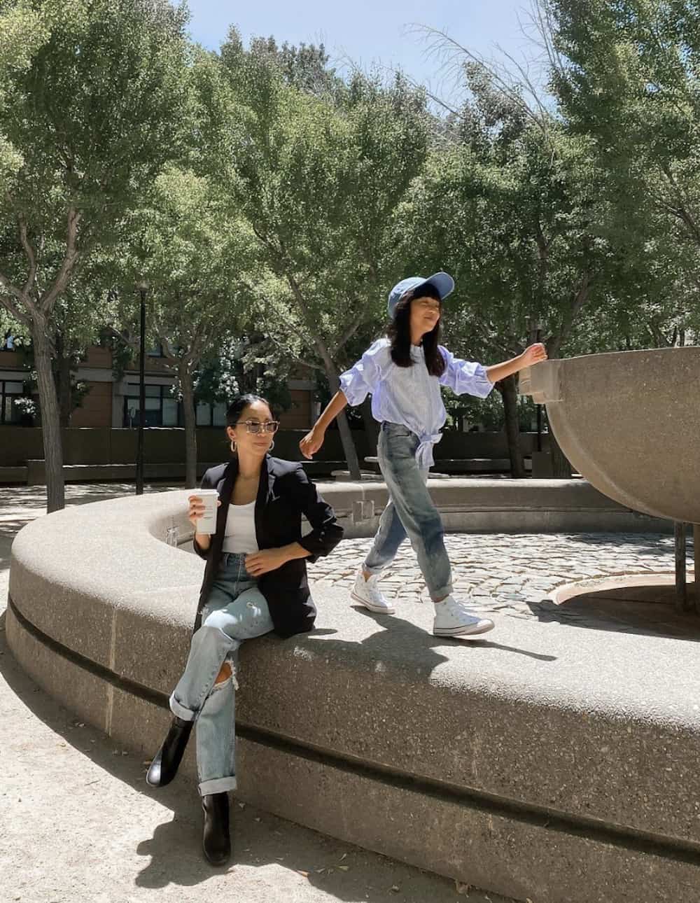 image of an asian woman and her daughter, she is wearing a black blazer, white t-shirt, blue jeans, and black boots