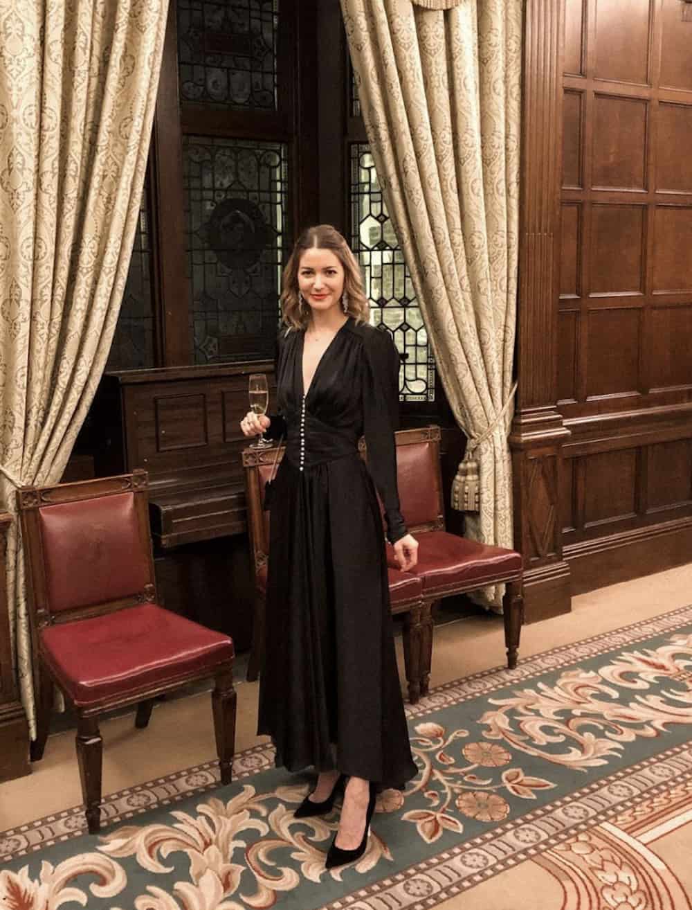 image of a woman in a long sleeve maxi black dress and black pumps