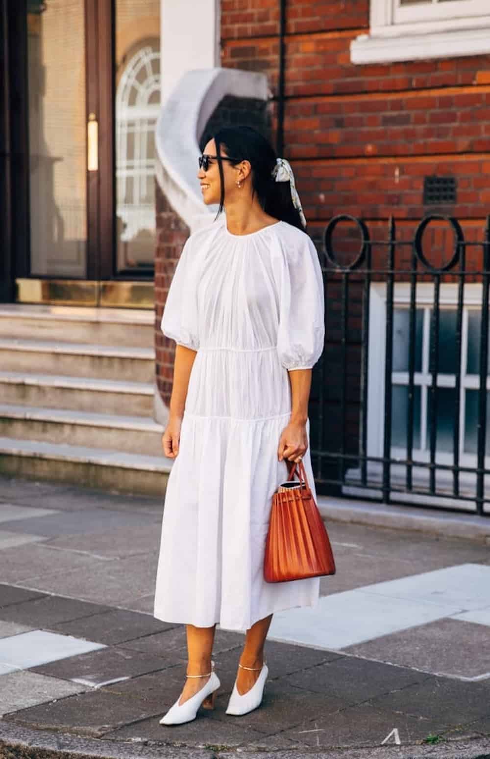 image of a woman wearing a long white puff sleeve dress and white heels