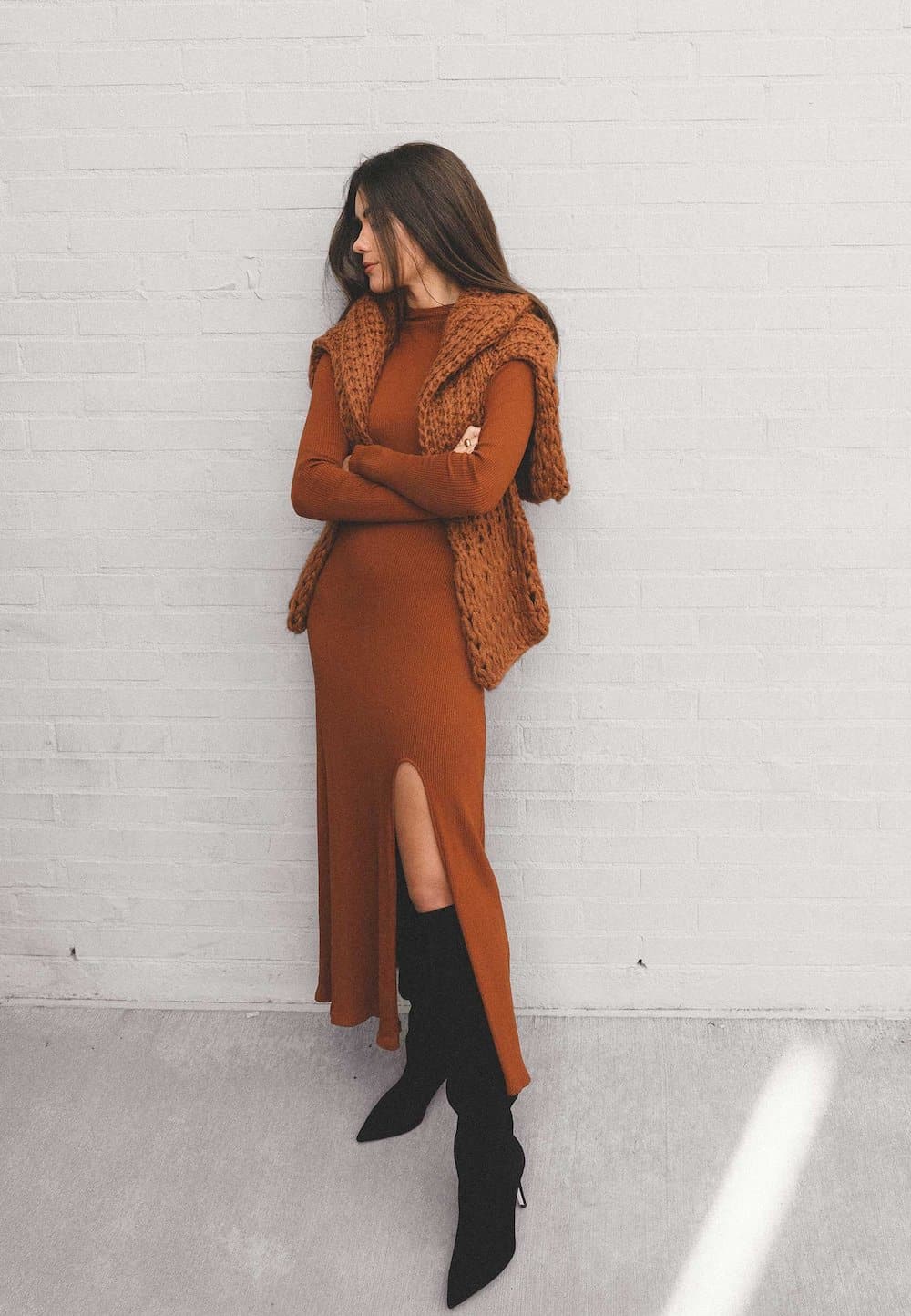 image of a woman wearing a long rust sweater dress with tall black suede boots
