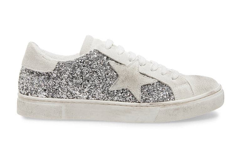 image of a silver glittered sneaker with a white star detail on the side and scuffs/distressing