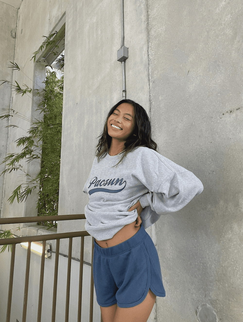 image of a young women in a grey pacsun sweatshirt and blue sweat shorts