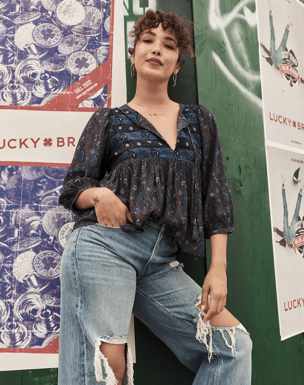 image of a woman in a floral peasant top and distressed jeans