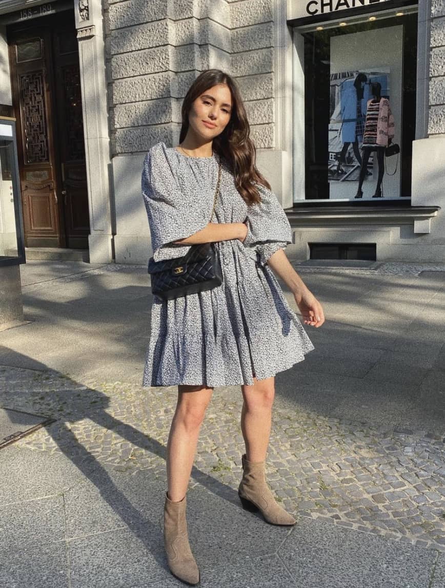 image of a woman in a floral long sleeve short dress with brown ankle boots