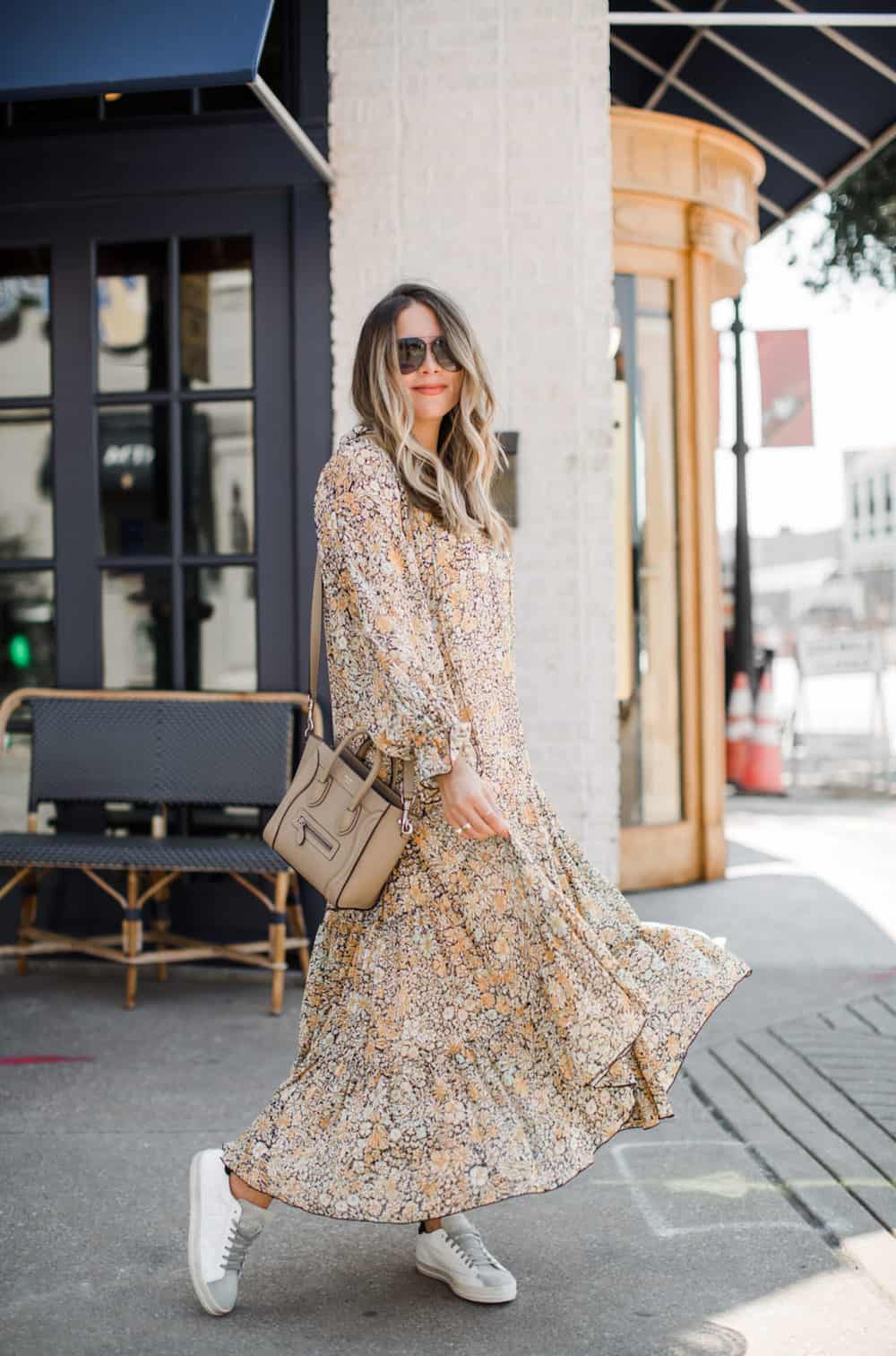 image of a woman wearing a long floral maxi dress and sneakers