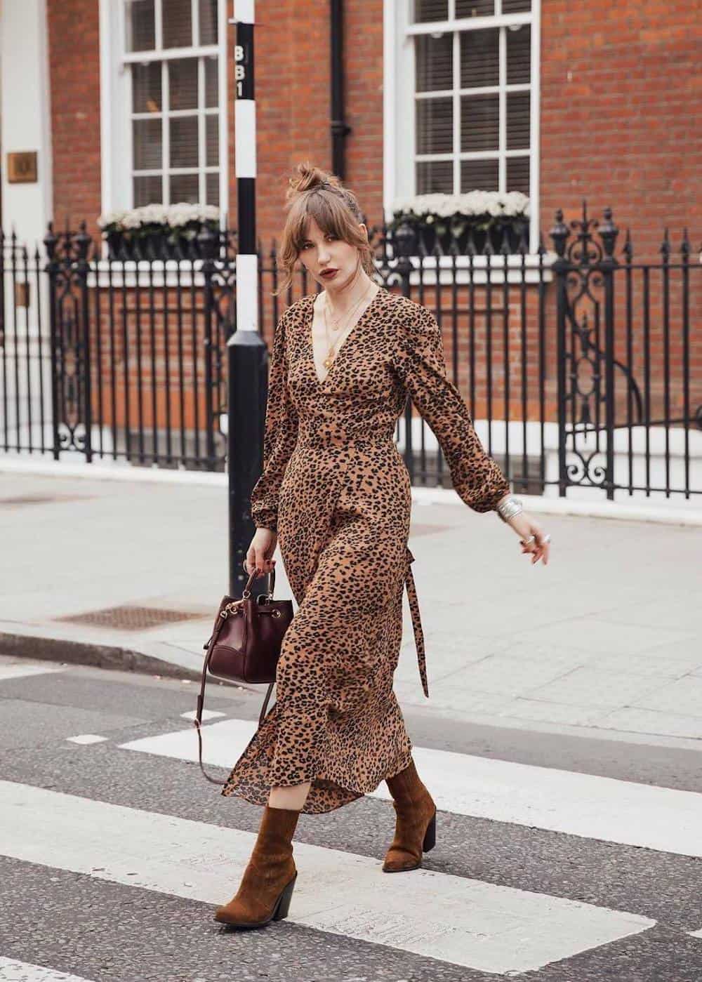 image of a woman wearing a long leopard print dress with brown suede ankle boots