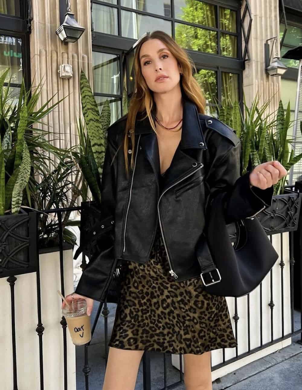 Woman wearing an animal print skirt and a black leather jacket.