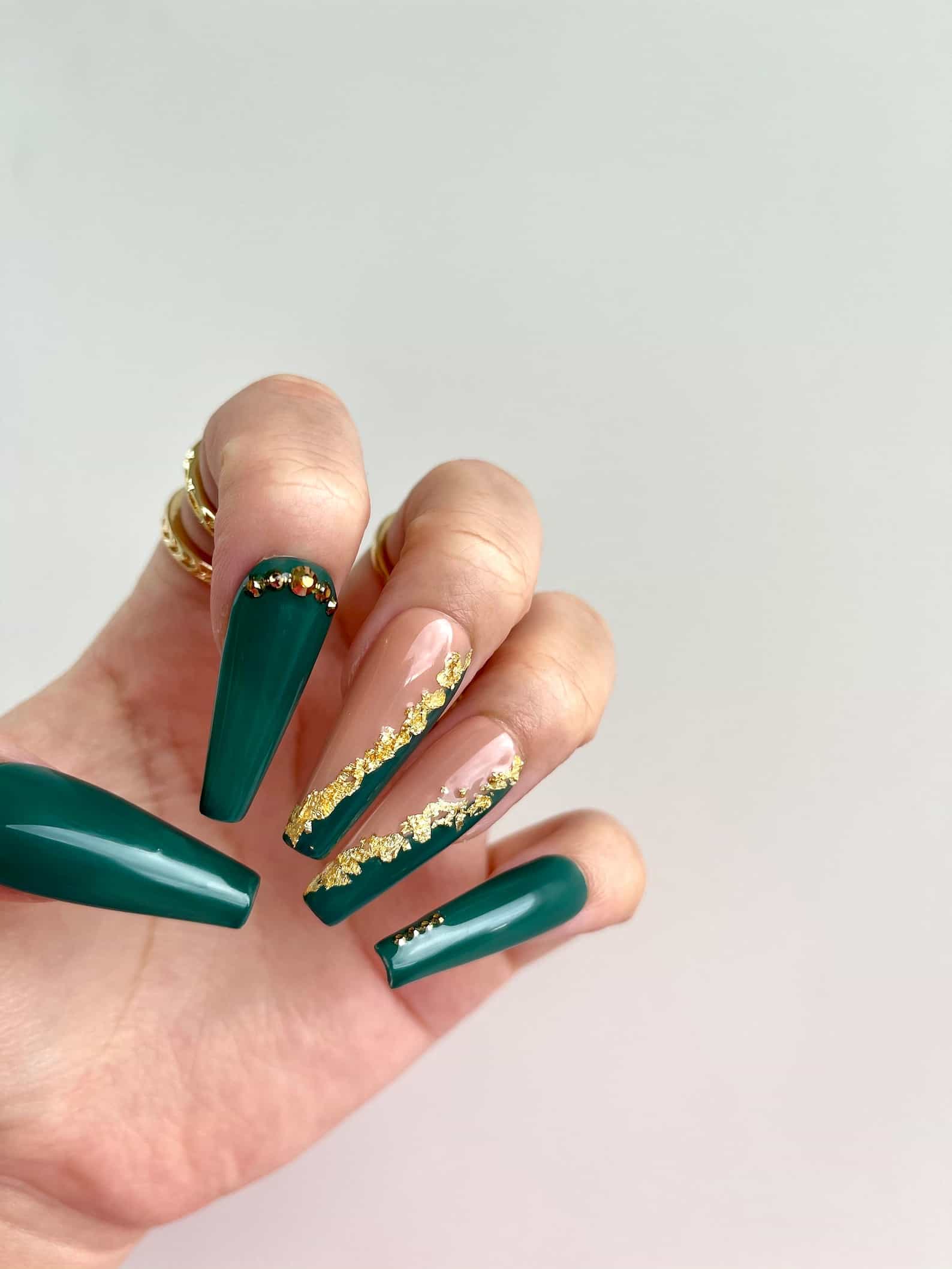 Long, coffin emerald green nails with gold leaf.