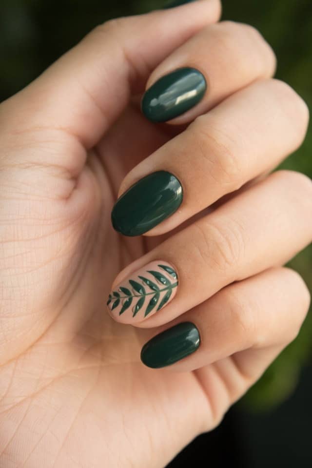 Emerald green nails with a leaf accent nail.