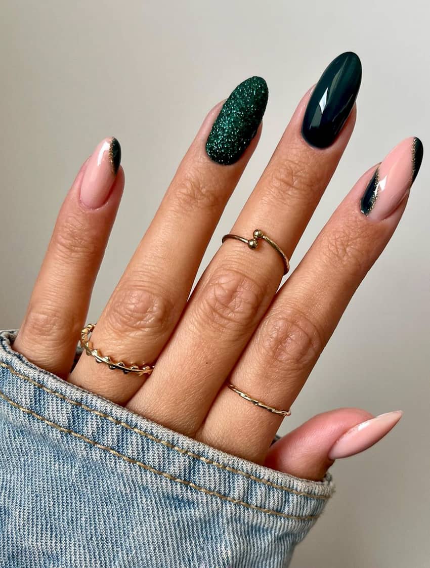 Manicure with emerald green sparkles and geometric shapes.