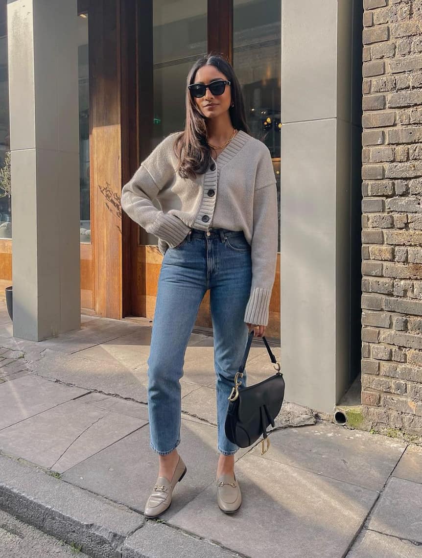 image of a woman wearing a taupe knit cardigan, jeans, and taupe Gucci loafers