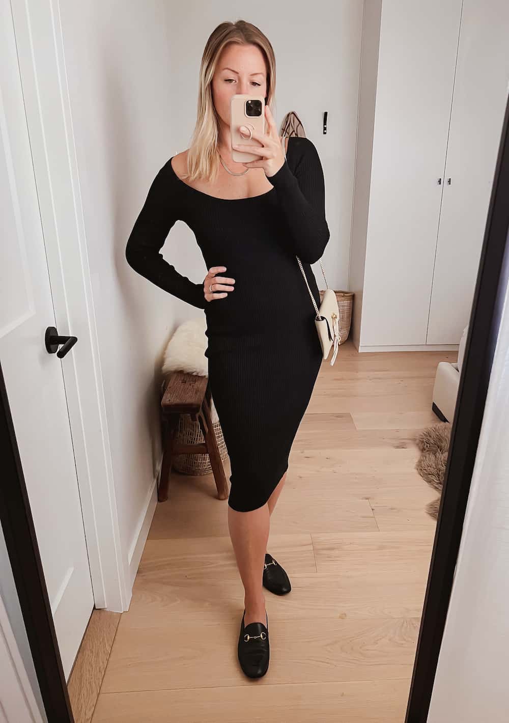 image of a woman wearing a midi-length black sweater dress and black Gucci loafers