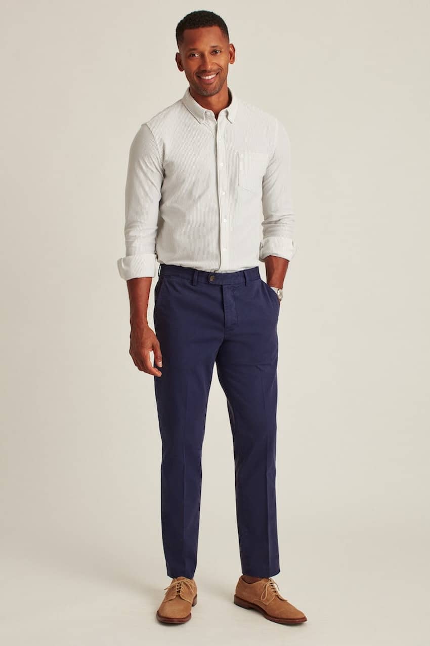 image of a black man wearing blue chinos with brown dress shoes and a button up shirt