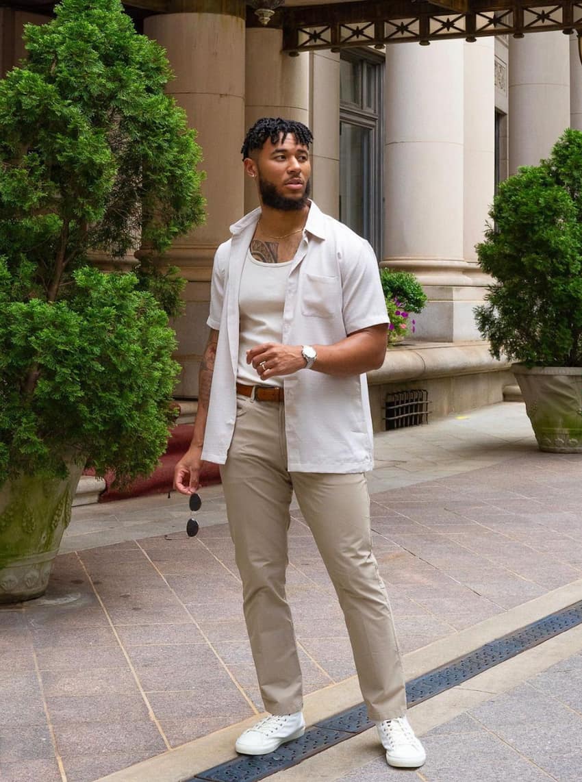 image of a black man wearing tan chinos, white sneakers, and a white button up shirt