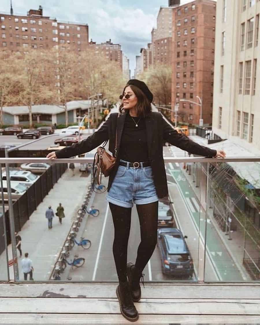 image of a woman in a cute outfit with denim shorts, black tights, and a black top