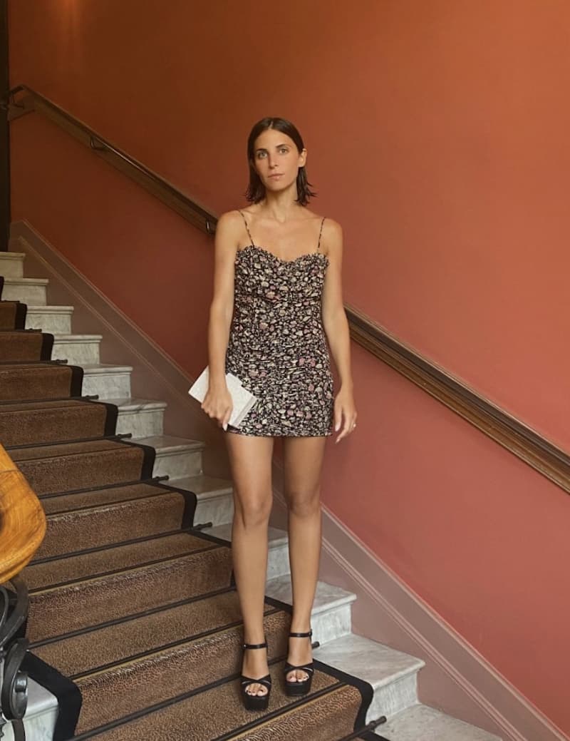 image of a woman standing on stairs wearing a pretty floral mini dress