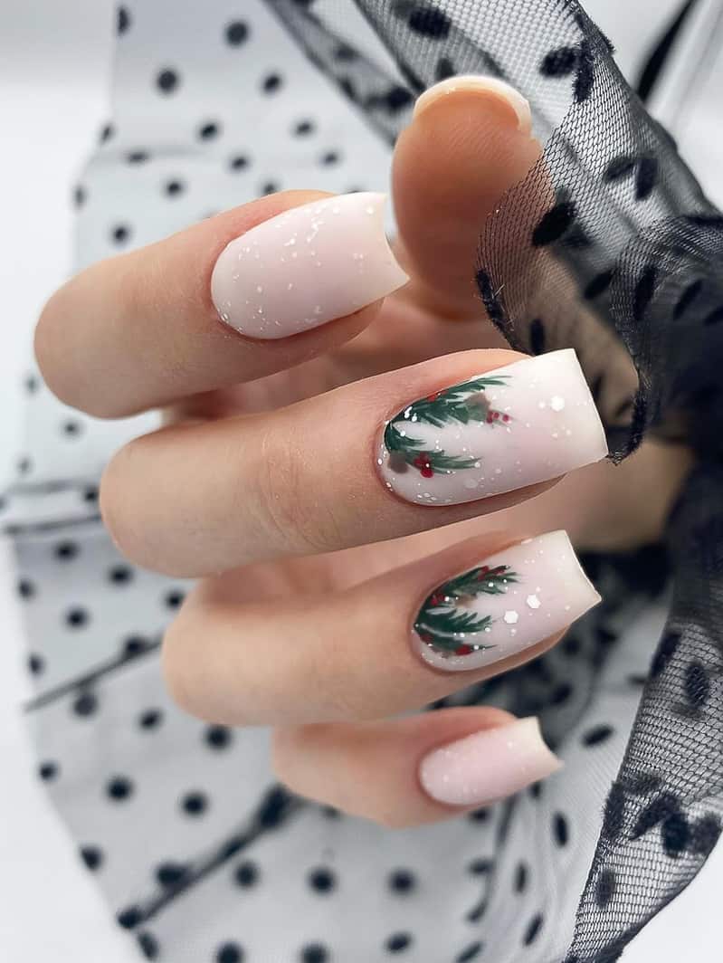 image of a hand with white coffin nails and a green leaf Christmas design