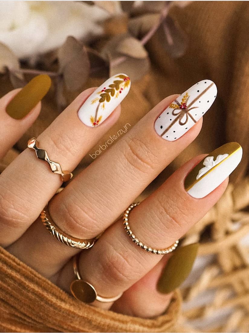 image of hand with white Christmas nails with gold and brown present art