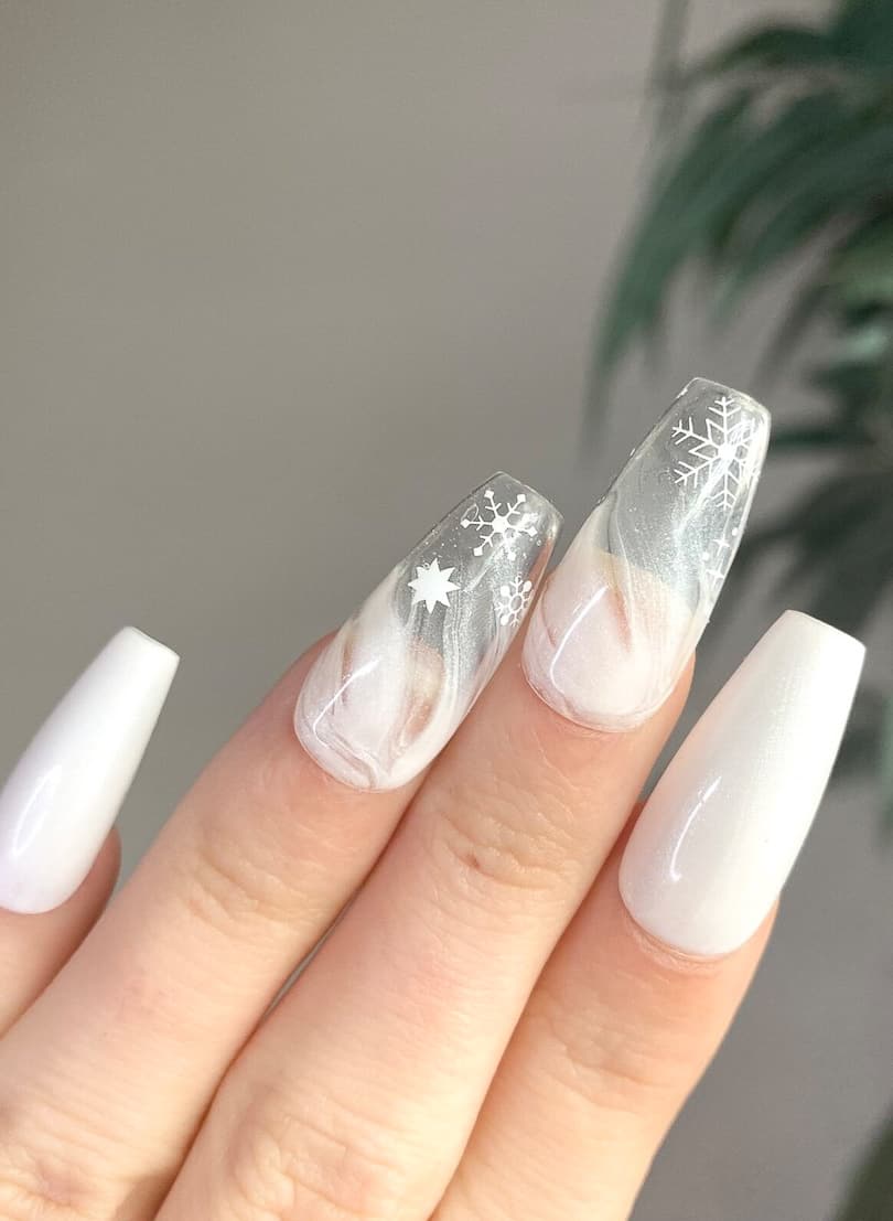 image of a hand with white and clear nails with a winter snowstorm design 