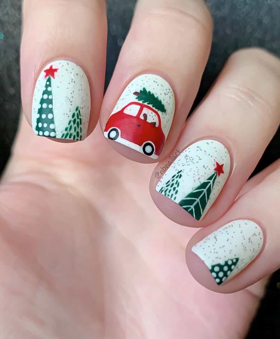 image of a hand with white nails with Christmas art including trees and a little red car with a tree on top